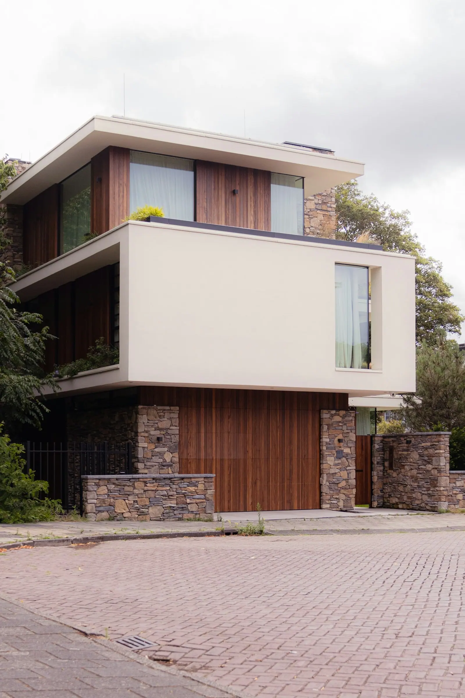 Fachada blanca con puertas y ventanas de madera